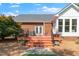 Brick home exterior with deck area featuring stairs and patio seating at 8733 Crowder Rd, Raleigh, NC 27603