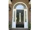 Close-up of a black front door with decorative glass, sidelights, and stylish outdoor sconces at 8733 Crowder Rd, Raleigh, NC 27603