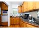 Charming kitchen with wooden cabinets, granite countertops, and a stainless steel sink by the window at 8733 Crowder Rd, Raleigh, NC 27603