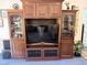 Entertainment center with display shelves and cabinets for storage, and a TV at 8733 Crowder Rd, Raleigh, NC 27603