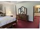 Well-appointed main bedroom featuring a dresser with a large mirror and access to the bathroom at 8733 Crowder Rd, Raleigh, NC 27603