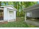 Shed with adjacent covered porch, offering additional storage and outdoor seating area at 8733 Crowder Rd, Raleigh, NC 27603