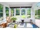 Bright sunroom with large windows offering scenic views of the backyard, comfortable seating, and tranquil decor at 8733 Crowder Rd, Raleigh, NC 27603