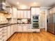 Well-appointed kitchen with stainless steel appliances, custom cabinets, and hardwood floors extending to the refrigerator at 91 E Walker Woods Ln, Clayton, NC 27527