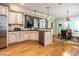 Open-concept kitchen with granite countertops, stainless steel appliances, and breakfast bar overlooking a casual dining area at 91 E Walker Woods Ln, Clayton, NC 27527