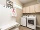 Functional mudroom with a built-in bench, coat hooks, storage cabinets, and a washer and dryer set at 91 E Walker Woods Ln, Clayton, NC 27527