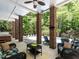 Relaxing covered patio with brick columns looks out to a pool and a wooded yard at 91 E Walker Woods Ln, Clayton, NC 27527