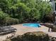 Sparkling kidney-shaped pool surrounded by stone and black lounge chairs at 91 E Walker Woods Ln, Clayton, NC 27527