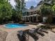 Beautiful backyard pool area with a fountain, lounge chairs, and mature landscaping creating a private oasis at 91 E Walker Woods Ln, Clayton, NC 27527