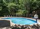 Sparkling kidney-shaped pool has an elegant brick surround, fountain features, and lounge chairs at 91 E Walker Woods Ln, Clayton, NC 27527