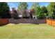 Lush backyard with mature trees, garden beds, and a sturdy retaining wall, offering privacy and a serene outdoor retreat at 1005 Fulbright Dr, Morrisville, NC 27560