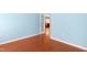 Bedroom showcasing blue walls, wooden floors, and a view into the kitchen at 1005 Fulbright Dr, Morrisville, NC 27560