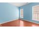 Serene blue bedroom with hardwood floors and two windows providing ample natural light at 1005 Fulbright Dr, Morrisville, NC 27560