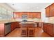 Well-lit kitchen featuring wood cabinets, an island with seating, and stainless appliances at 1005 Fulbright Dr, Morrisville, NC 27560