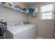Laundry room with a window, appliances, shelving, and neutral walls at 1009 Open Field Dr, Garner, NC 27529