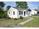 Charming home exterior with white siding, a stone walkway, and neatly manicured lawn at 102 Allen St, Graham, NC 27253