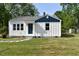 Charming home featuring white siding, a blue accent, and a well-manicured lawn at 102 Allen St, Graham, NC 27253