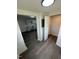 View of a hallway, showing access to a closet, with gray wood floors, and a view to the kitchen at 102 Allen St, Graham, NC 27253