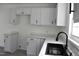 Bright kitchen features white cabinets, sleek black hardware, and marble-look countertops at 102 Allen St, Graham, NC 27253