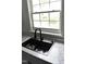Close-up of a modern black sink and faucet under a window with a view outside at 102 Allen St, Graham, NC 27253
