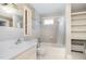 Well-lit bathroom with a shower-tub combo, white tiling, and a matching toilet and sink at 103 E Meadowbrook Dr, Smithfield, NC 27577