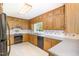 Traditional kitchen with wooden cabinetry, laminate countertops, and essential appliances at 103 E Meadowbrook Dr, Smithfield, NC 27577