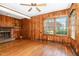 Cozy living room featuring wood paneling, hardwood floors, and a brick fireplace at 103 E Meadowbrook Dr, Smithfield, NC 27577