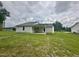 A well-maintained home exterior featuring a covered patio, lush backyard, and pristine siding at 107 Earnest Way, Kenly, NC 27542