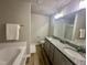Bathroom featuring a double sink vanity with granite countertop, bathtub, walk-in shower, and wood-look flooring at 107 Earnest Way, Kenly, NC 27542