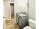 Bright bathroom featuring granite countertop, grey cabinetry, and hardwood style floors at 107 Earnest Way, Kenly, NC 27542