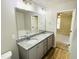 Bathroom with double vanity featuring granite countertops and a view to the bedroom at 107 Earnest Way, Kenly, NC 27542