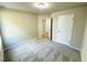 Neutral carpeted bedroom with a window and door leading to a hallway at 107 Earnest Way, Kenly, NC 27542