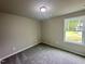 Cozy bedroom with a carpeted floor, a neutral color scheme, and a window offering a peaceful view at 107 Earnest Way, Kenly, NC 27542