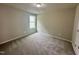 Spare bedroom featuring plush carpeting, neutral walls, and a window, ideal for relaxation or customization at 107 Earnest Way, Kenly, NC 27542