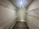 Walk-in closet offering ample storage space with multiple wire shelves, and carpeted flooring at 107 Earnest Way, Kenly, NC 27542