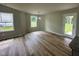 Bright dining area with wood-look floors, large windows, and a modern light fixture creating a warm and inviting space at 107 Earnest Way, Kenly, NC 27542