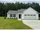 Charming single-Gathering home featuring a two-car garage, well-manicured lawn, and classic architectural details at 107 Earnest Way, Kenly, NC 27542