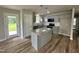 Kitchen featuring gray cabinets, stainless steel appliances, a door to the backyard, and a gray stone island at 107 Earnest Way, Kenly, NC 27542