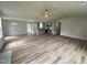 Living room with wood-look flooring flowing to the kitchen area and many windows for natural lighting at 107 Earnest Way, Kenly, NC 27542