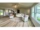 Cozy living room with wood-look flooring, a plush sofa, and multiple windows that bring in natural lighting at 107 Earnest Way, Kenly, NC 27542