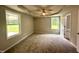 Spacious main bedroom with tray ceiling, ceiling fan, carpeted floors, and a bathroom, providing a relaxing retreat at 107 Earnest Way, Kenly, NC 27542