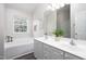 Bright bathroom featuring a dual sink vanity and a soaking tub under a bright window at 110 Stoney Dr, Durham, NC 27703
