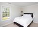 Bright bedroom featuring a dark wood bed frame and a large window at 110 Stoney Dr, Durham, NC 27703