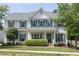 Charming two-story home featuring light siding, green shutters, a manicured lawn and mature landscaping at 110 Stoney Dr, Durham, NC 27703
