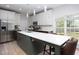 Bright kitchen featuring stainless steel appliances, a large island with seating, and a view to the backyard at 110 Stoney Dr, Durham, NC 27703