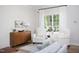 Comfortable sitting area features plush white chairs, a wood accent table, and natural light from the large window at 110 Stoney Dr, Durham, NC 27703