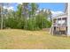 Expansive backyard featuring a well-maintained lawn, trees, and views of the home and screened porch at 113 Old Ballentine Way, Holly Springs, NC 27540