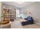 Cozy room with ample book storage and a comfortable lounging area by a bright window at 113 Old Ballentine Way, Holly Springs, NC 27540