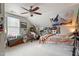 Bright bedroom featuring a ceiling fan, eclectic decor, and unique personal touches at 113 Old Ballentine Way, Holly Springs, NC 27540