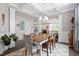 Inviting dining room featuring a stylish rug, rustic dining table, and modern chandelier at 113 Old Ballentine Way, Holly Springs, NC 27540